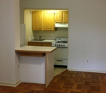 A kitchen with wooden cabinets and a white counter.